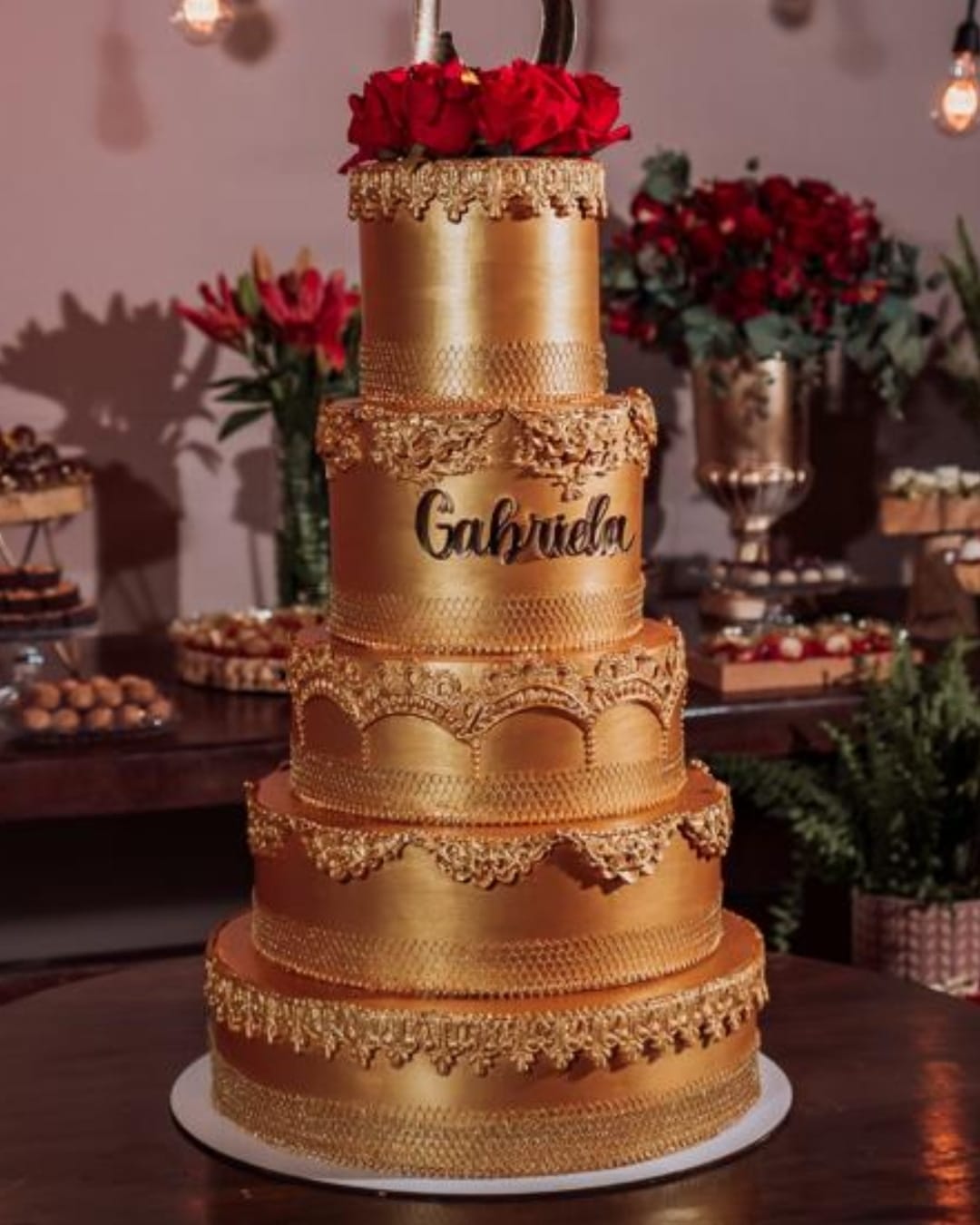 Bolo fake dourado luxuoso para festa de 15 anos com nome personalizado.