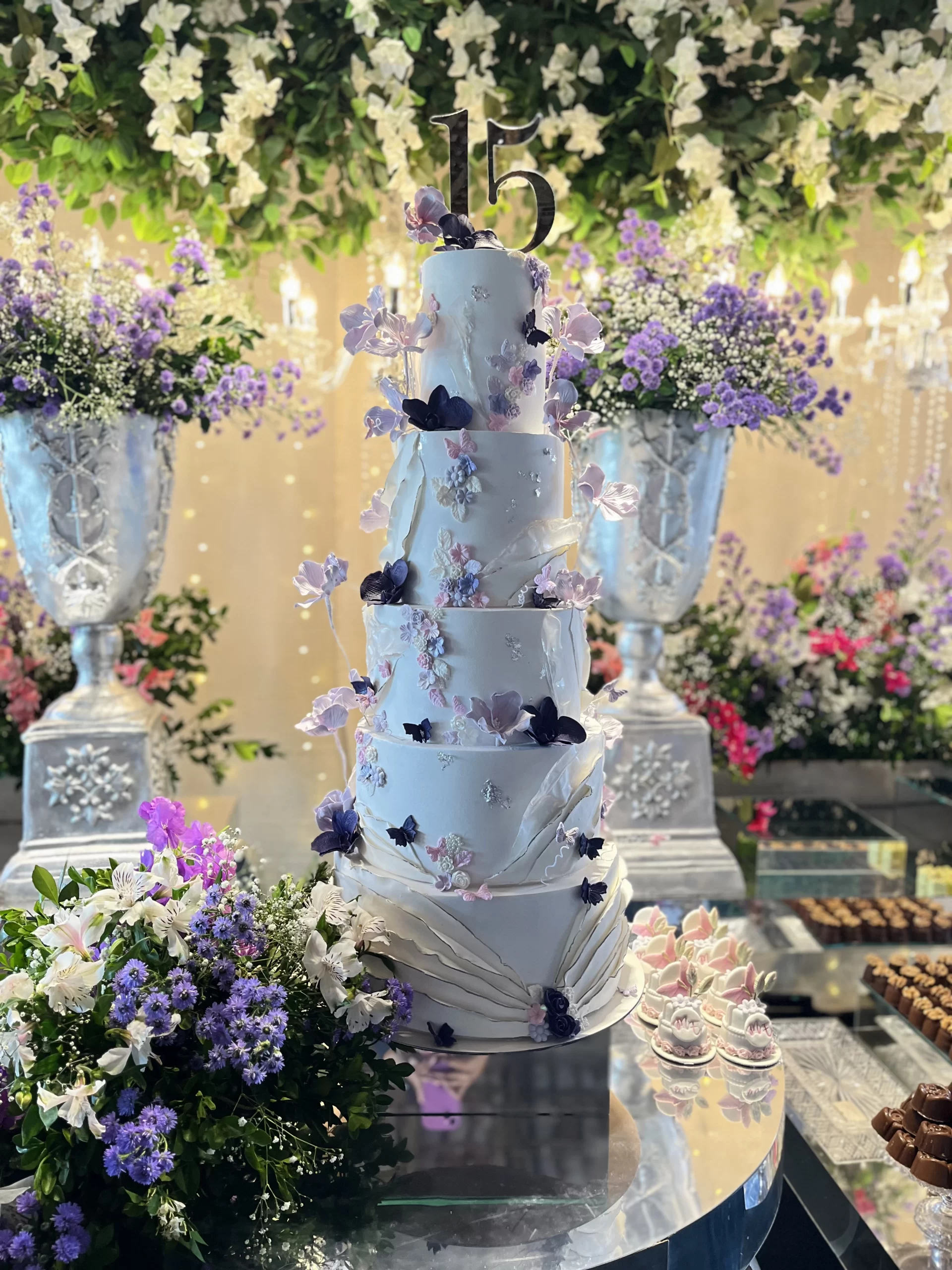 Bolo fake 6 andares com borboletas 3D e flores lilás para 15 anos.